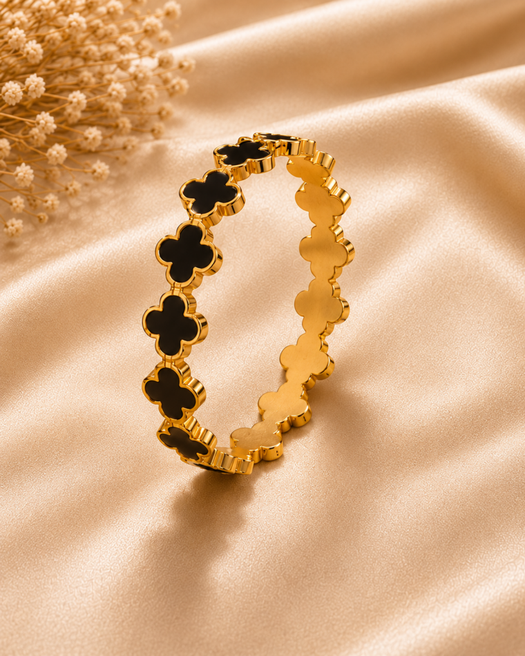 One gold four-leaf clover bangle with black shell inlays on champagne satin