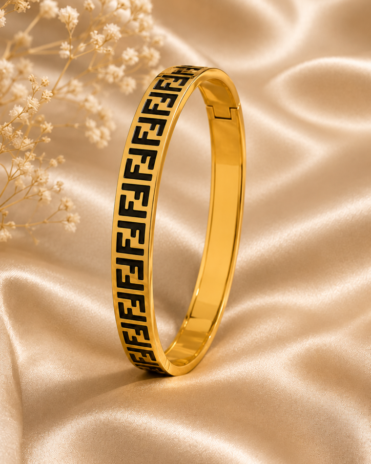 One black and gold Greek key bangle on champagne satin